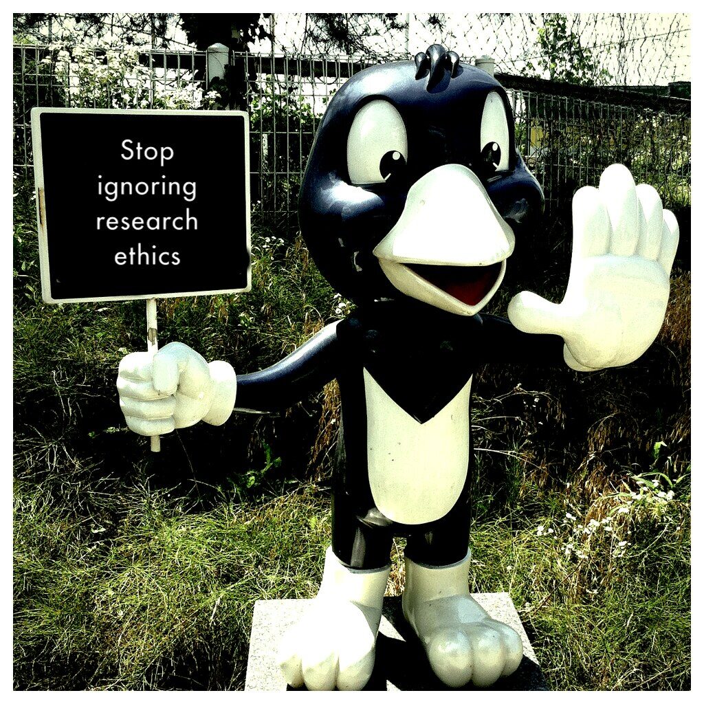 Image of a mascot holding a sing saying 'stop ignoring research ethics'