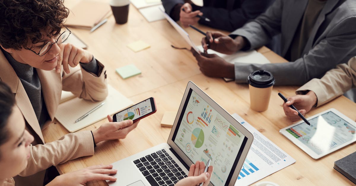 Photo for what is seo copywriting portfolio: laptop on a desk displaying analytics charts, printed notes and a smartphone, suggesting content performance review.
