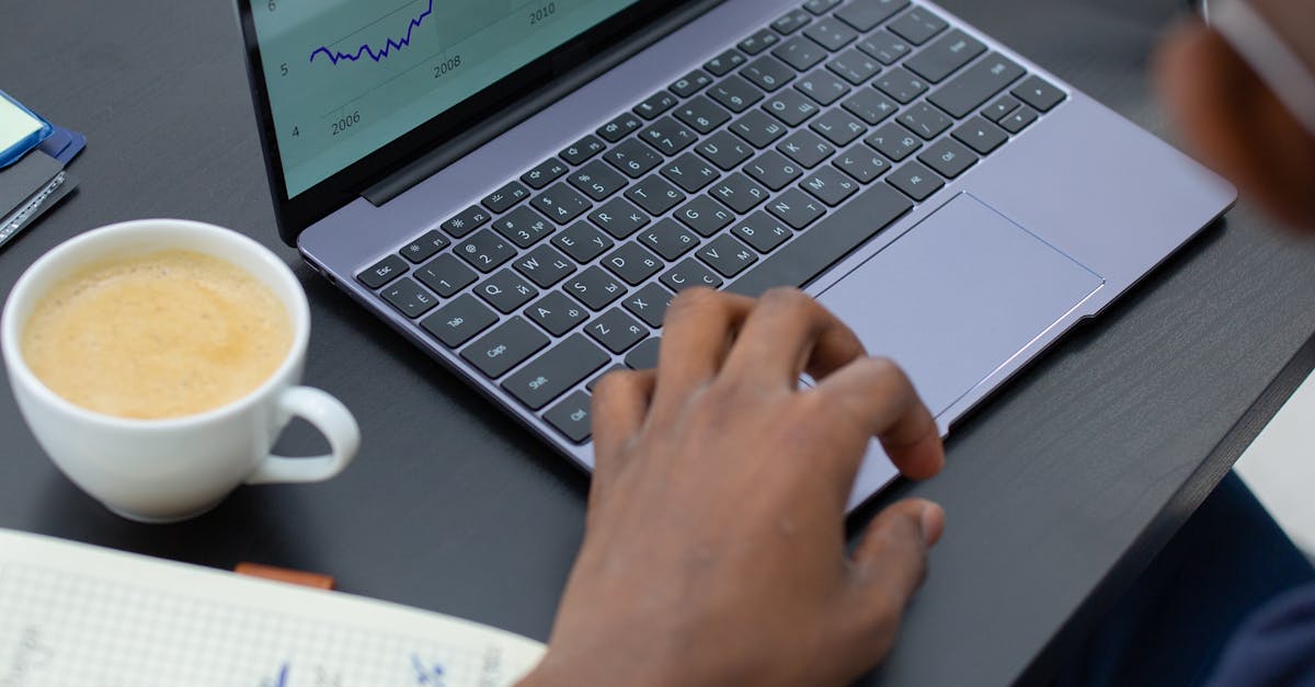 A person typing on a laptop with SEO graphs and icons floating around, illustrating what is seo copywriting in practice.